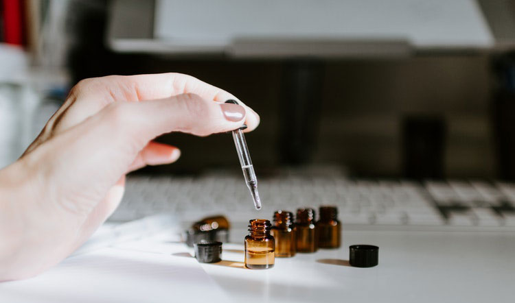 A Woman Squeeze CBD From a Dropper Into Small Brown Bottle