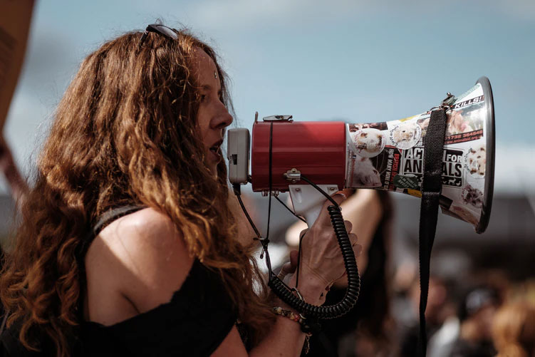 A female protestor speaks into a megaphone