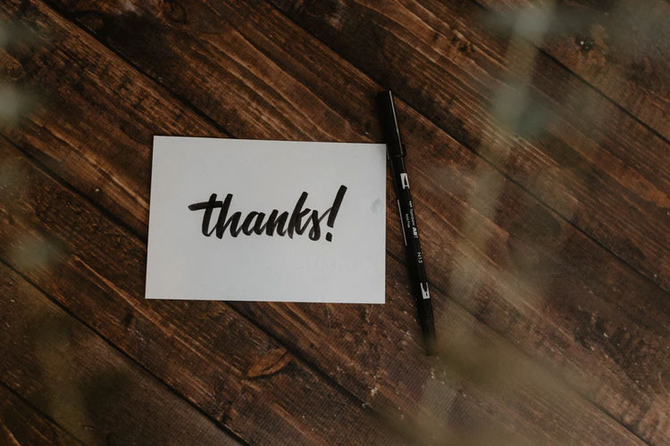 A notecard with “Thanks!” written on it in black ink