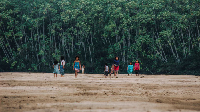 Amazonian children walk along the Jungle’s edge.
