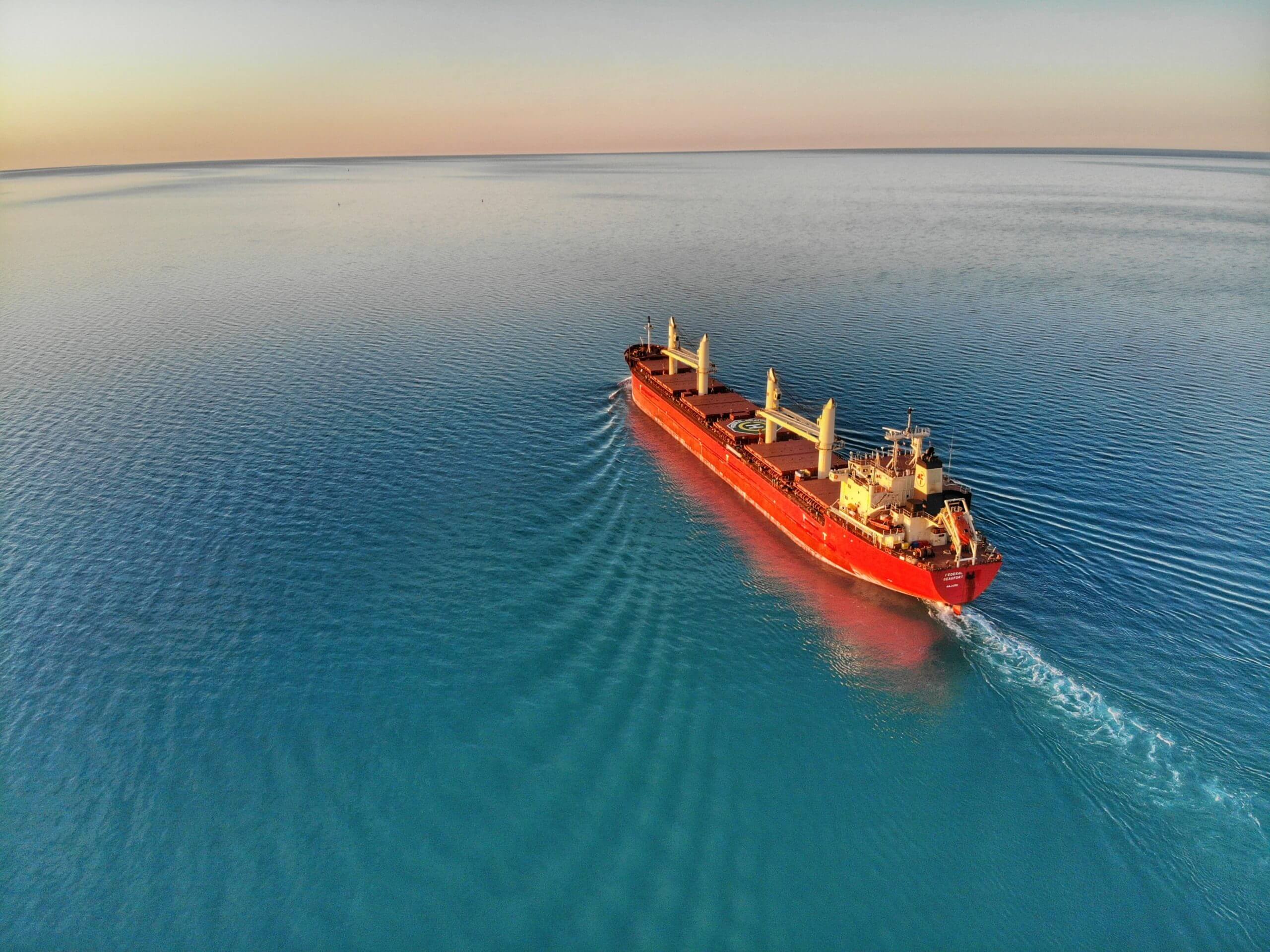red shipping freighter with no shipping containers on a vast expanse of water