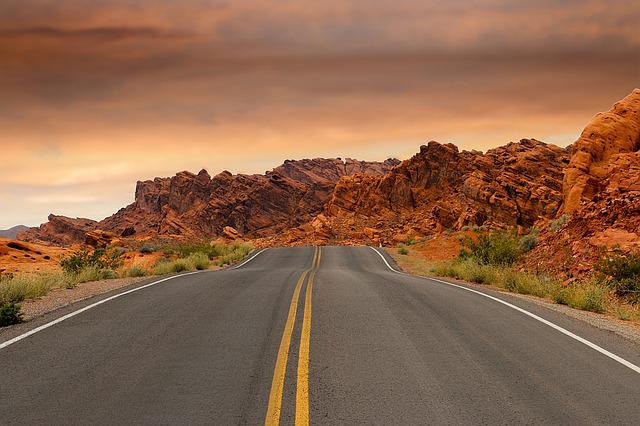 Nevada road at sunset with sandstone hills along the horizon