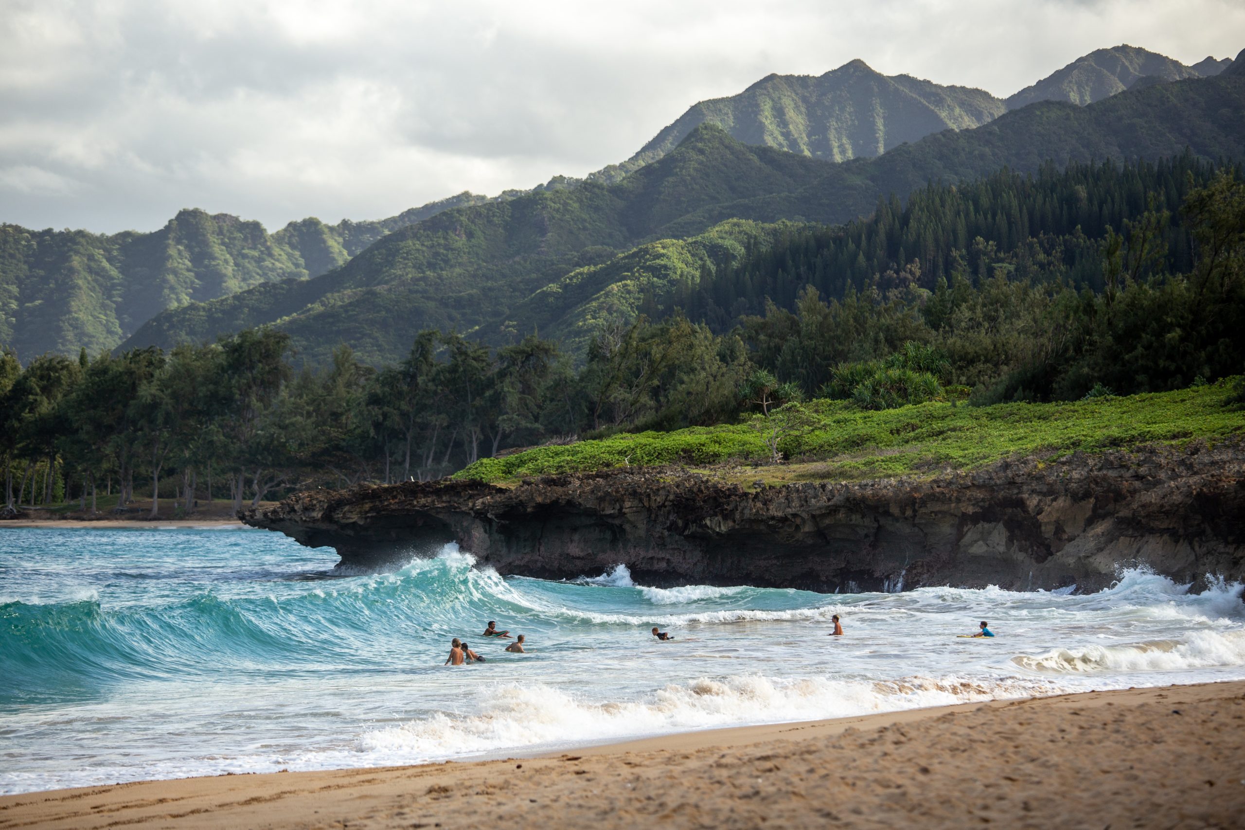 daytime on Hawaii shore with green mountains in the background