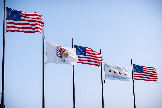 U.S. and Illinois flags against a blue sky