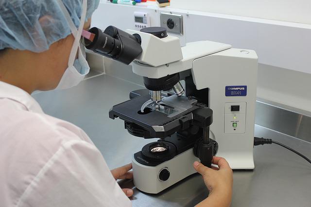 Woman gazing into a microscope in a laboratory 