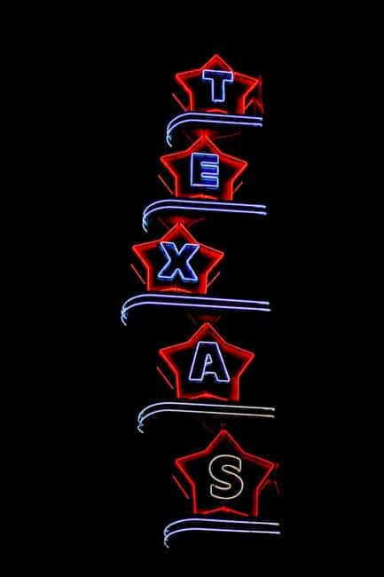 Vertical neon sign that spells out the word Texas