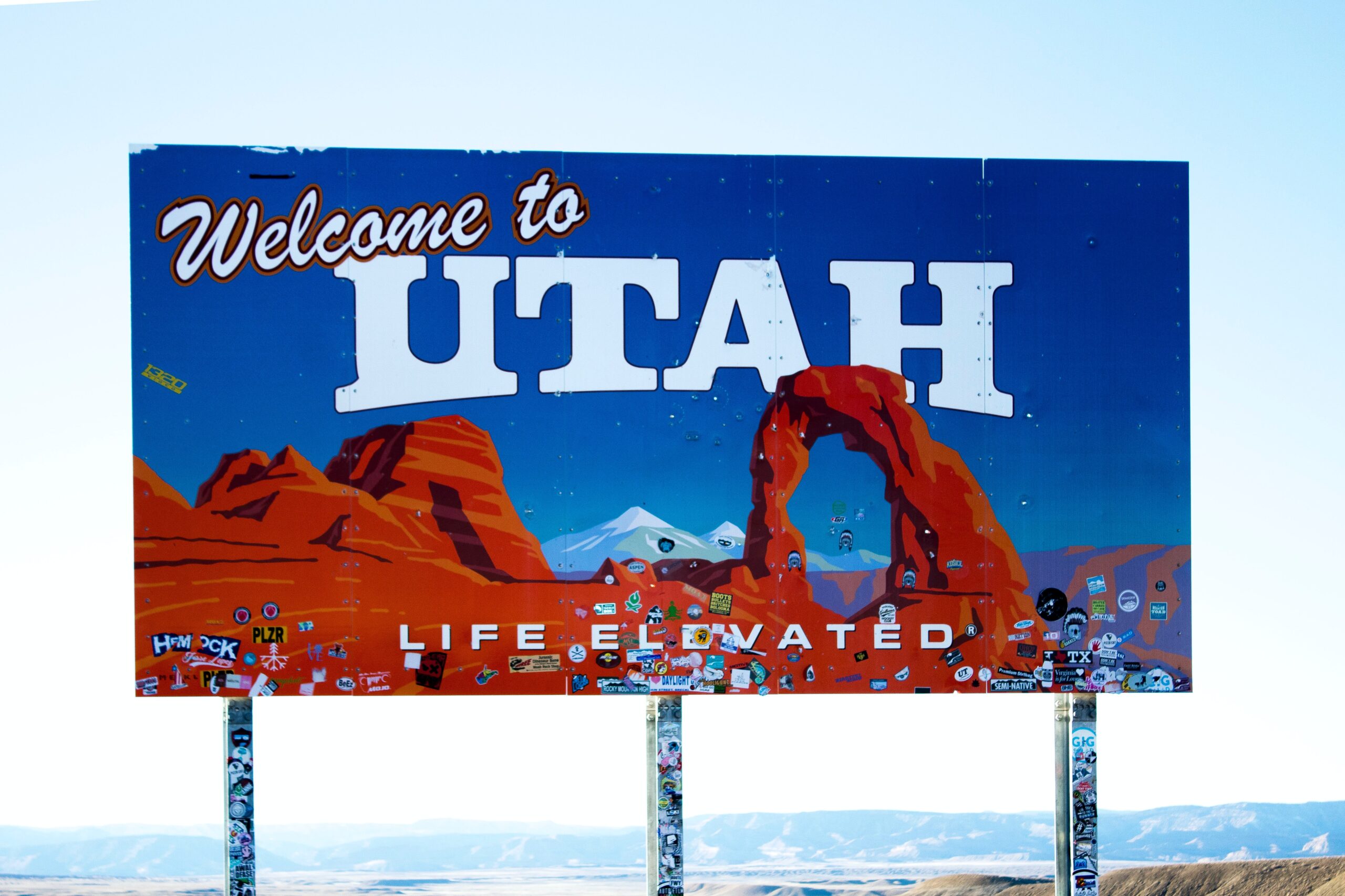 Welcome to Utah billboard with red rocks against a blue sky