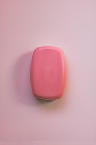 Large pink soap bar on a pale pink background