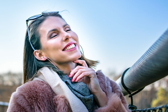 smiling woman in a pink fur coat