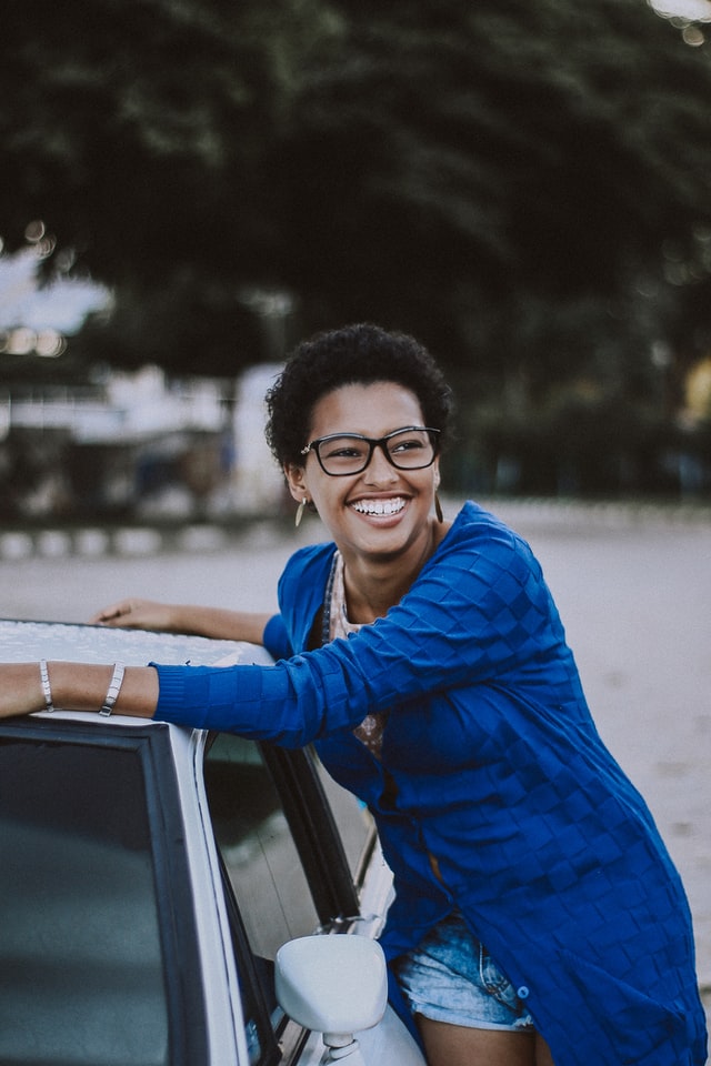 Woman in a blue cardigan smiling outside a truck.