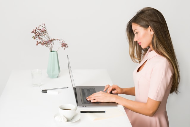 woman sitting while using a laptop