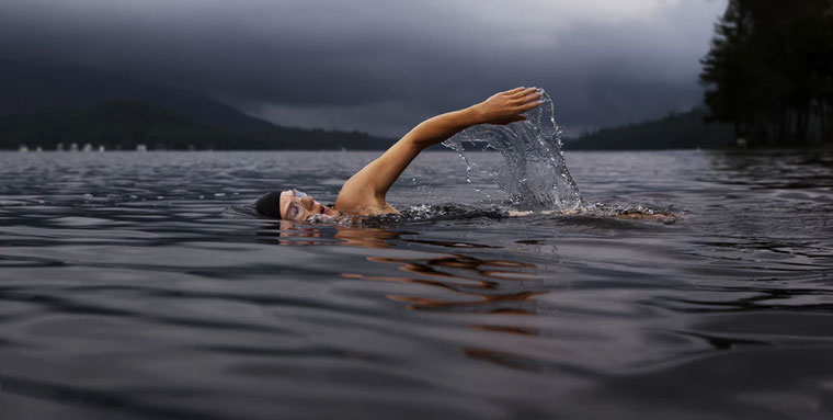 Woman swims in the ocean as part of her holistic fitness plan