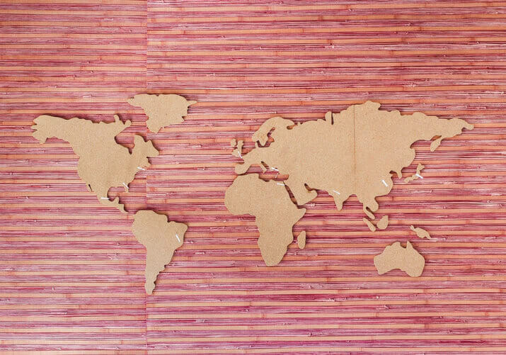 A brown cut-out of a world map on a red background